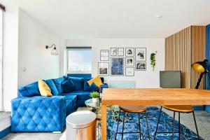 a living room with a blue couch and a table at Sheffield Penthouse with Rooftop Terrace & FREE Parking in Sheffield