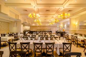 a banquet hall with tables and chairs and chandeliers at Royal Plaza Hotel in Tiberias