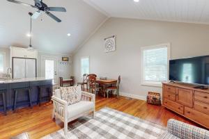 a living room with a flat screen tv and a kitchen at Cozy Pines in Flat Rock