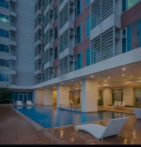 a swimming pool in front of a building at 8 Adriatico Manila Condotel Sea View Corner Unit Near St Lukes Clinic in Manila
