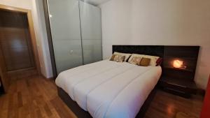 Un dormitorio con una gran cama blanca en una habitación. en La Casa de Sira - A 5 min de la playa a pie - Parking incluido, en Luanco 11 fotos más