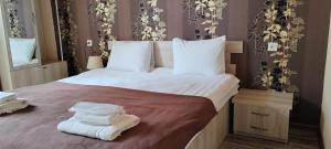 a bedroom with a large bed with towels on it at Hotel Svanseti in Mestia