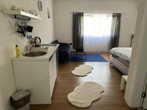 a bathroom with a sink and two rugs on the floor at Apartmani Art in Jajce +28 photos