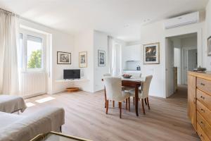 a white living room with a table and chairs at IseoLakeRental - Fantasy Lake in Castro