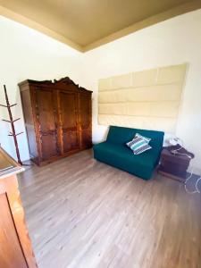 a living room with a blue couch and a wooden floor at Casa Bizzacchi Pinhal in Espirito Santo Do Pinhal