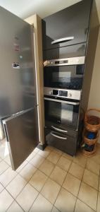 a kitchen with a stainless steel stove and refrigerator at Maison Hortensias Fromentine 8 pers près de la plage in La Barre-de-Monts