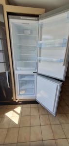 an empty refrigerator with its doors open in a kitchen at Maison Hortensias Fromentine 8 pers près de la plage in La Barre-de-Monts