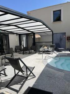 a patio with chairs and a swimming pool at Hotel Best Western La Mare Ô Poissons in Ouistreham
