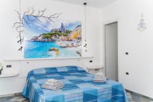 a bedroom with a bed with a painting on the wall at Apposentos in via Baus in Santa Maria Navarrese