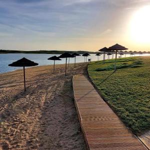 una fila di ombrelloni su una spiaggia accanto all'acqua di Casa do Pátio - Barragem do Alqueva a Granja