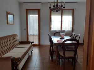 a dining room with a table and chairs and a couch at La Casa di Marti in Arezzo