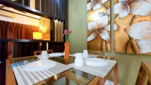 a dining room with a table and a painting of flowers at Gold Coast Morib Apartment in Banting +9 photos