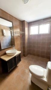 a bathroom with a toilet and a sink and a mirror at Gold Coast Morib Apartment in Banting