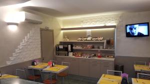 un ristorante con due tavoli e una cucina con tv di Hotel Le Querce a Milano