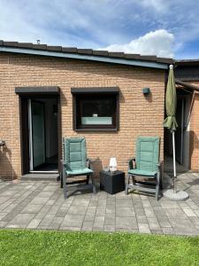 two chairs and an umbrella on a patio at Auszeit Apartment Düsseldorf in Düsseldorf