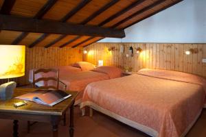 a bedroom with three beds and a table with a book at Logis Hôtel La Petite Chaumière in Gex