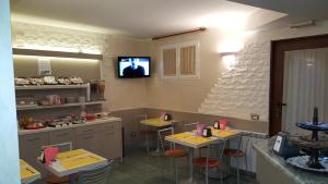 a kitchen with two tables and a tv on the wall at Hotel Le Querce in Milan