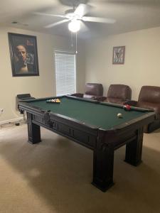 een pooltafel in een woonkamer met stoelen bij Warren Seabrook in Covington