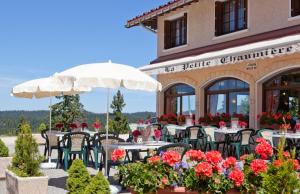 ein Restaurant mit Tischen und Stühlen vor einem Gebäude in der Unterkunft Logis Hôtel La Petite Chaumière in Gex