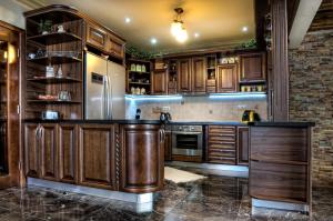 a kitchen with wooden cabinets and a stainless steel refrigerator at Mountain Resort Ždiar - Chalets in Ždiar