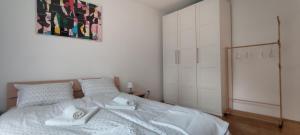 a bedroom with a white bed with towels on it at Zg City suite in Zagreb
