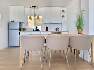 a kitchen with a wooden table and chairs at Apartament 3-sypialnie na plazy i garaż in Torrevieja
