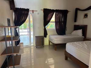 a bedroom with two beds and a window at Bungalow Girasol Barra la Saladita Planta Alta in La Salada