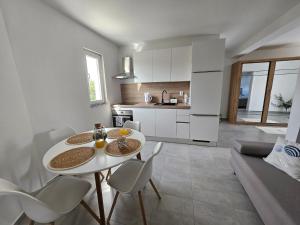 a kitchen and living room with a white table and chairs at Aniva in Drage