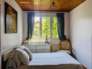 a bedroom with a bed and a window and a chair at Charmante maison à Rueil-Malmaison in Rueil-Malmaison