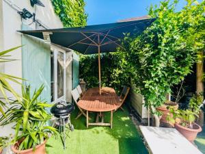 a patio with a table and an umbrella at Charmante maison à Rueil-Malmaison in Rueil-Malmaison