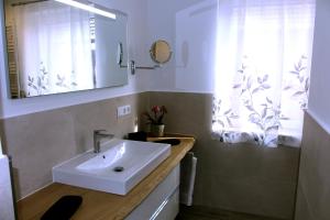 a bathroom with a sink and a mirror and a window at Haus Deutsche Bucht in Borkum +107 photos