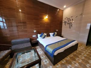 a bedroom with a bed and a table and a couch at HOTEL HOLY CITY in Amritsar
