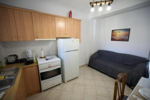 a small kitchen with a refrigerator and a bed at Blue Dreams Astros in Paralio Astros