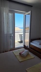a bedroom with a bed and a window with a view of the ocean at Apartment Lukovo - Puskaric in Lukovo