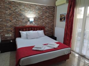 a bedroom with a bed with towels on it at Hotel Villa Pigasos in Paralia Katerinis
