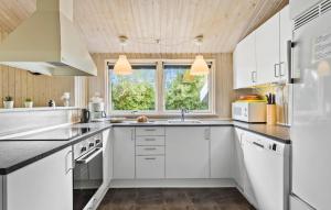 a kitchen with white cabinets and a window at Holiday Home Udsigten Iv in Spodsbjerg