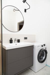 a bathroom with a washing machine and a sink at SEKLER Apartments in Cluj-Napoca