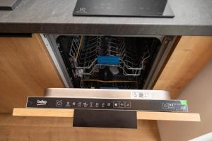 a dishwasher with a laptop on top of it at SEKLER Apartments in Cluj-Napoca +16 photos