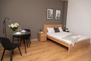 a bedroom with a bed and a table and chairs at SEKLER Apartments in Cluj-Napoca
