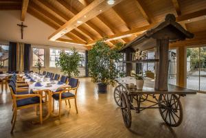 ein Esszimmer mit einem Tisch und einem Pferdewagen in der Unterkunft Landhotel Weißer Hahn in Wemding