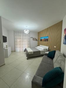 un soggiorno con un divano e un letto di Fabiria Guesthouse - B&B a Pagani