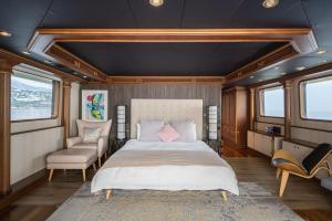 a bedroom with a bed and a chair and windows at iRama Luxury Superyacht 6 Cabins & Hot Tub & Water Toys in Cannes