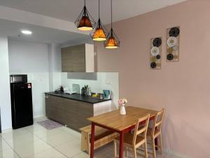 a kitchen with a wooden table and a black refrigerator at Qsara Home Gamuda Garden in Rawang