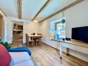 a living room with a table and a television at Stella Alpina - Romantic getaway in Falcade