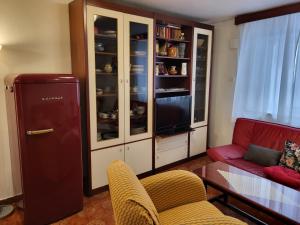 a living room with a tv and a red couch at Sobe pri Anici in Koper