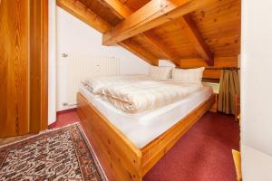 a bedroom with a bed in a room with wooden ceilings at Ferienwohnung Mahlert im Haus Sonnenschein in Reit im Winkl