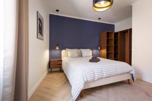 a bedroom with a bed and a blue wall at L'Oranger T4 Elegant and bright Prime Location in Grasse