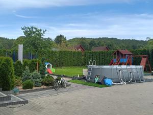 a bike parked in a parking lot next to a playground at Apartamenty Lubkowo in Lubkowo