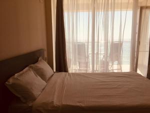 a bedroom with a bed with a large window at Lemon in Costinesti