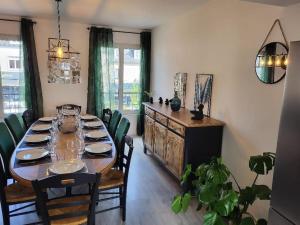 a dining room with a long table and chairs at L'Antre des Généraux in Percy